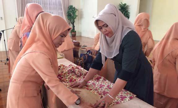 ketua-tp-pkk-kab-siak-misnarni-syamsuar-mempraktekan-cara-membuat-baju-di-gedung-wanita