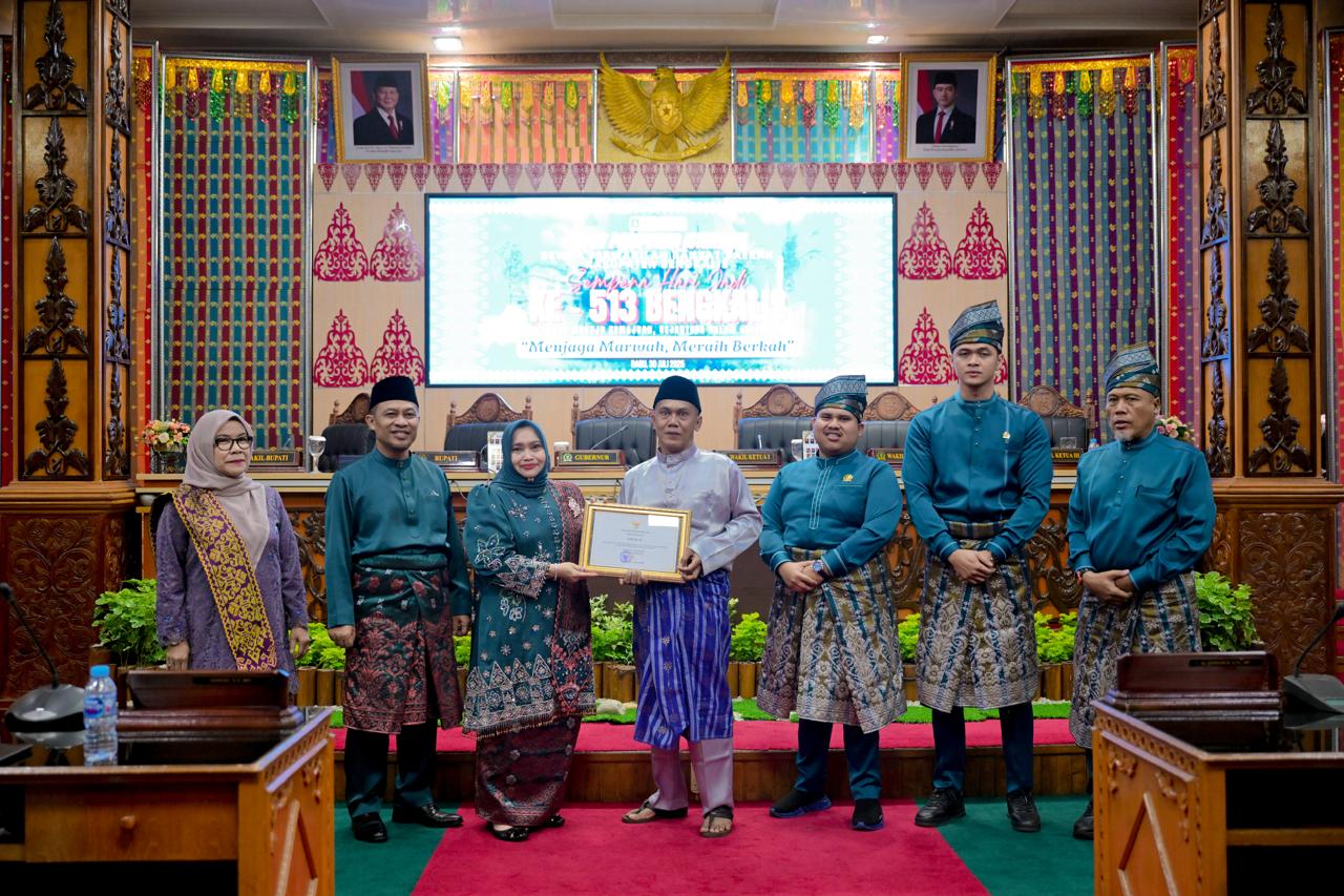 Bupati Bengkalis Kasmarni menyerahkan piagam kepada Asmar pencipta lambang atau logo Kabupaten Bengkalis yang diterima