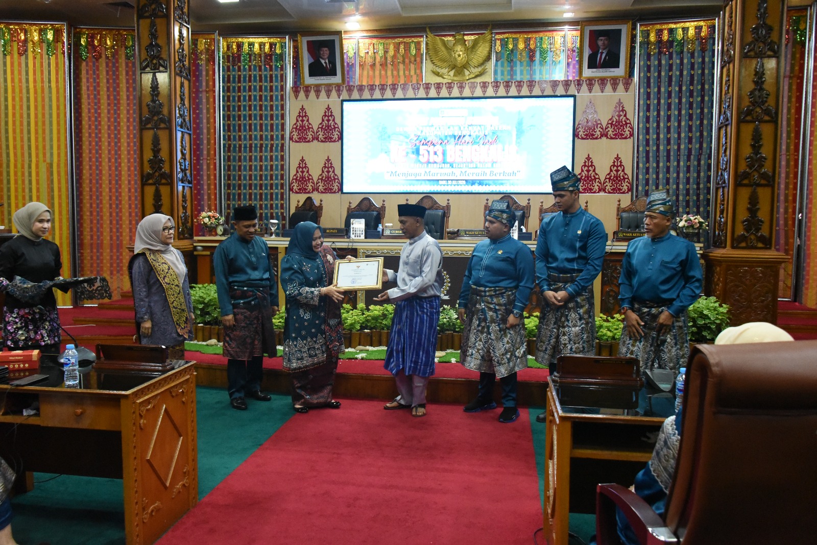 Bupati Bengkalis Kasmarni menyerahkan piagam kepada Asmar pencipta lambang atau logo Kabupaten Bengkalis yang diterima