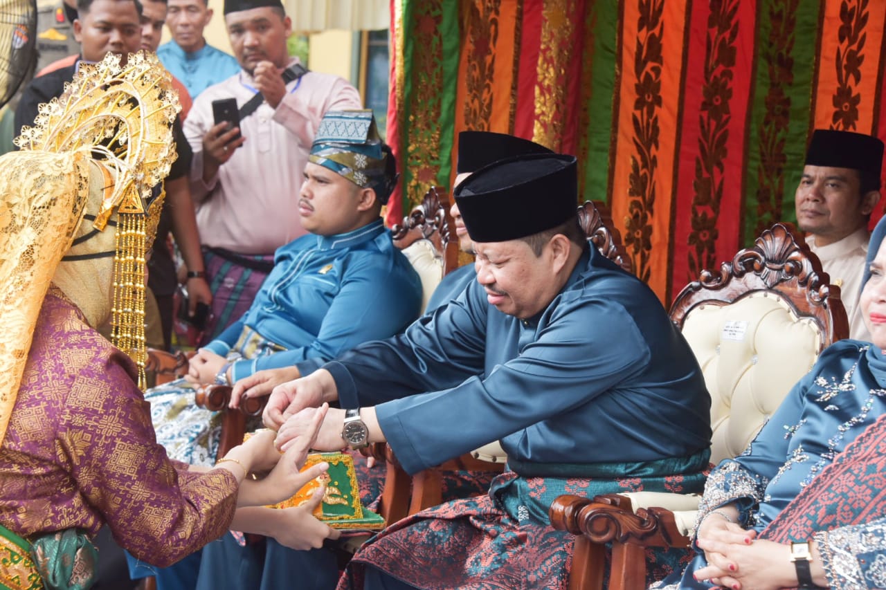 Mantan Bupati Bengkalis ke-14 Amril Mukminin mengambil sirih dalam tepak yang disajikan penari